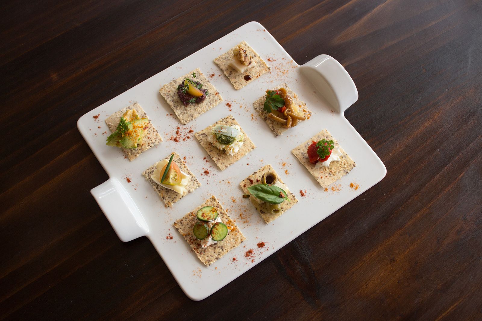 Galletas saladas con distintos acompañamientos, servidas en bocados